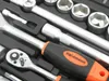 A close-up view of a socket wrench set, showing the ratchet handle and several sockets. Podgląd zdjęcia produktu