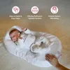 A baby sleeping in a white baby nest on a bed, with marketing text overlays. Anteprima dell’immagine prodotto