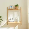 A wooden shelf mounted on a wall, decorated with a framed picture, a potted plant, books, a clock, and a decorative sculpture. Voir les images du produit