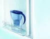 A blue water filter pitcher sits on a shelf inside a refrigerator. Náhled obrázku produktu