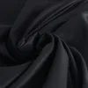 A close-up, studio shot of black fabric, folded and draped to show its texture and sheen. Produktbild-Vorschau