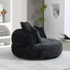 A dark chenille lazy sofa with three pillows is placed in a modern living room setting, next to a shelf with decor and books, and a plant. Podgląd zdjęcia produktu
