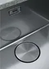 A close-up view of a stainless steel sink with a drain cover and a brand logo. Produktbild-Vorschau
