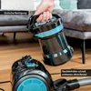 A hand is holding a detached dustbin from a vacuum cleaner, with the main body of the vacuum cleaner visible on the floor. Produktbild-Vorschau