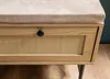 Close-up of a bench with a rattan front and a fabric seat. Voir les images du produit