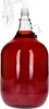 A glass carboy filled with red liquid, fitted with a fermentation airlock. Produktbild-Vorschau