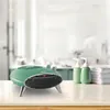 A green retro-style electric heater sits on a countertop in a bathroom setting, with soap dispensers and towels in the background. Podgląd zdjęcia produktu