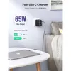 A fast USB-C charger plugged into a wall outlet, charging a MacBook Pro. Produktbild-Vorschau