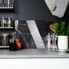 A kitchen counter with a marble cutting board, spice grinders, and a plant. Náhľad obrázku produktu