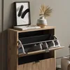 A shoe cabinet with shoes inside, placed on a shelf with a painting and a vase. Náhľad obrázku produktu