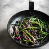 Green beans and red cabbage being cooked in a black frying pan. Podgląd zdjęcia produktu