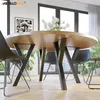 A modern dining room with a round wooden table and black chairs, featuring a vase of white tulips. Anteprima dell’immagine prodotto