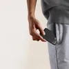 A person is putting a black power bank into the pocket of their grey sweatpants. Produktbild-Vorschau