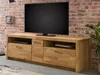 A wooden TV stand with a television on top, set against a brick wall. Produktbild-Vorschau