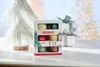 A gift set of Yankee Candle votive candles is displayed on a table with a decorative Christmas tree and a wrapped gift in the background. Náhľad obrázku produktu