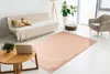 A living room scene with a couch, armchair, coffee table, and a rug. Produktbild-Vorschau