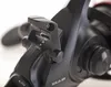 Close-up of a fishing reel's drag adjustment lever and dial. Produktbild-Vorschau