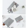 A collage of three images showing a grey fabric organizer bag with shoes, socks, and electronic accessories. Voir les images du produit