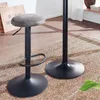 Two bar stools are shown on a patterned rug in a room with wooden floors and curtains in the background. Produktbild-Vorschau