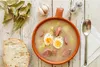 A bowl of soup with sausage and eggs, served with bread and bay leaves. Náhľad obrázku produktu