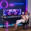 A man is sitting in a gaming chair at a gaming desk with dual monitors, holding a game controller. Voir les images du produit
