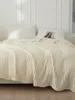 A cream-colored blanket is draped over a bed with white pillows. Podgląd zdjęcia produktu