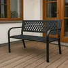 A black metal garden bench with a lattice backrest sits on a wooden deck in front of a building with a window and a wooden door. Anteprima dell’immagine prodotto