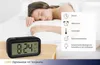 A woman sleeping in bed next to a digital alarm clock, with a graphic overlay detailing the clock's features. Náhled obrázku produktu
