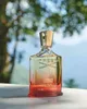 A perfume bottle is placed on a surface with a blurred natural background of trees and sky. Anteprima dell’immagine prodotto