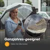 A woman holding an umbrella and looking at her phone while it's raining, with a close-up of a shoe in the rain. Produktbild-Vorschau