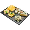 A cheese platter with various types of cheese, nuts, and herbs on a slate board. Náhled obrázku produktu