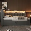 A bedroom scene featuring a gray upholstered bed with a built-in storage shelf and USB charging ports. Náhled obrázku produktu