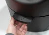 A hand is shown interacting with a black object, possibly a lever or handle, on a larger black product. Náhľad obrázku produktu