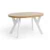 A round dining table with a light wood top and white criss-cross legs, shown from a slightly elevated side angle against a white background. Voir les images du produit