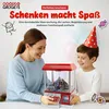 A mother and son are playing with a candy grabber toy. Produktbild-Vorschau