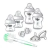 A collection of baby bottles, pacifiers, and a bottle brush arranged on a white background. Podgląd zdjęcia produktu