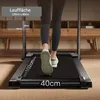 A person is walking on a treadmill in a room with wooden furniture. Produktbild-Vorschau