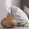 An aroma diffuser is shown in a bedroom setting with pillows in the background. Podgląd zdjęcia produktu