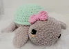 A crocheted turtle toy with a mint green shell and beige-gray body, adorned with a pink bow. Náhľad obrázku produktu