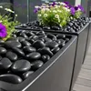 Schwarze Kieselsteine in einem Pflanzkübel mit Blumen Produktbild-Vorschau