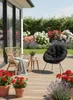 A patio scene with chairs, plants, and flowers. Anteprima dell’immagine prodotto