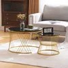 Two round coffee tables with black marble-look tops and gold metal bases are placed on a rug in a living room setting. A sofa is visible in the background. Náhľad obrázku produktu