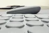 A close-up, low-angle shot of a keyboard with a computer mouse in the background. Produktbild-Vorschau
