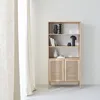 A light wood bookshelf with cane accents and decorative items. Produktbild-Vorschau