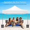 People enjoying themselves on a beach under a white canopy, with the ocean in the background. Produktbild-Vorschau