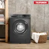 A washing machine is shown in a laundry room setting, next to a shelf with folded towels and a basket of laundry. Produktbild-Vorschau