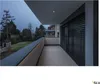A modern balcony overlooking a garden at dusk. Anteprima dell’immagine prodotto