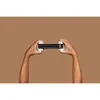 Two hands holding a pair of black ear defenders with white ends. Anteprima dell’immagine prodotto