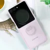 A lavender Samsung flip phone case with a ring attachment is shown on a white textured surface, next to a cup of tea. Anteprima dell’immagine prodotto