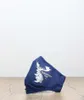 A folded navy blue face mask with a white graphic of a moose and text is placed on a wooden surface against a white background. Produktbild-Vorschau